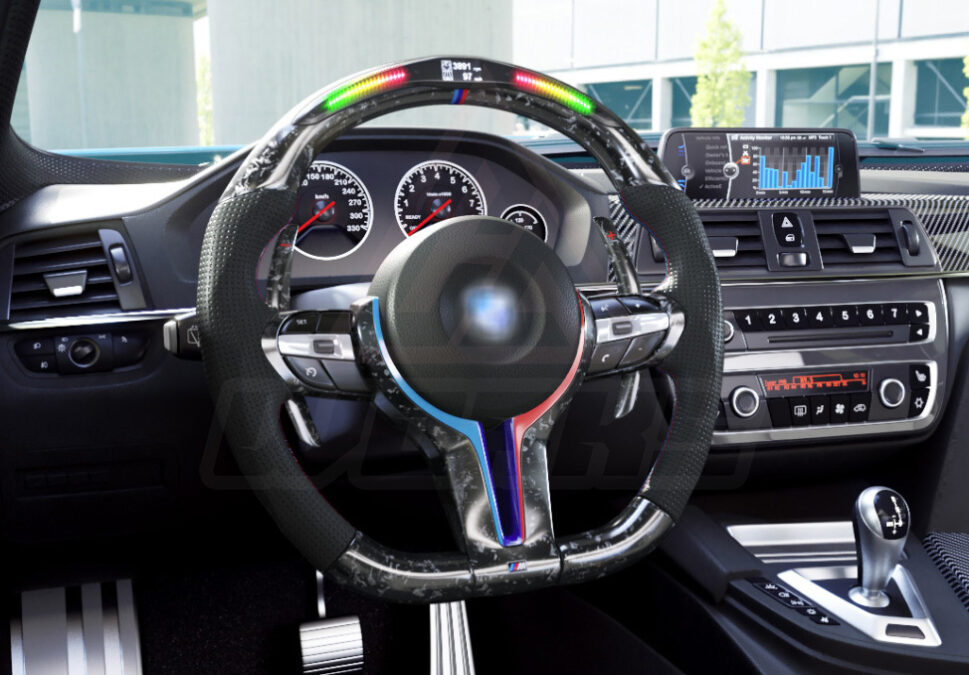 Side view of a BMW F chassis, M sport retrofit steering wheel in forged carbon fiber, extended paddle shifters, m color accents, black perforated leather, m color painted center trim, and led shift lights